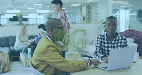 Obraz premium Collaborating man in mustard bomber jacket and woman typing at table in open office, with laptop