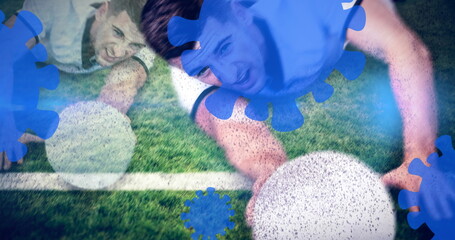 Diving athletes in blue jerseys stretching to reach white ball on grass field, with virus graphics