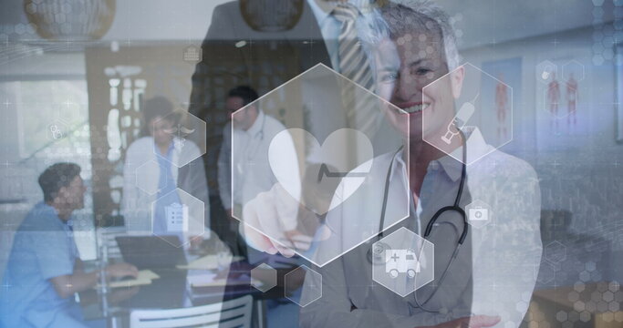 Holding senior doctor presenting interface in hospital meeting room, digital icons, copy space