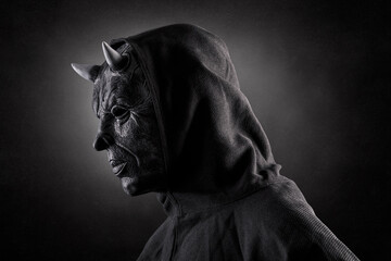 Portrait of a bad devil with horns on head over dark misty background