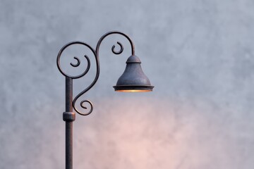 Vintage street lamp illuminates area. Old lamp post, classic style, warm light glow.