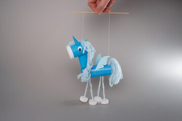 Creative handmade unicorn puppet held by hands on white background ideal for DIY tutorials kids...