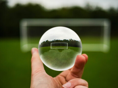 Soccer or football goal posts in glass ball, The ball is in someone hand. Forecasting sport results in popular world sport. Betting on club and national teams concept.