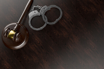 Gavel and Handcuffs on a Wooden Desk or Table Surface with Room for Copy.