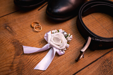 Elegant wedding details flatlay on rustic wooden background. Groom accessories - black leather...