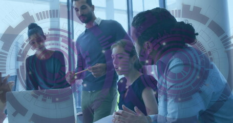 Five coworkers working around laptop on conference table, with documents overlay graphics