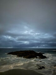 Obraz premium Sea at night on rocky beach shore.