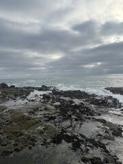 Storm clouds gather over sea shore.