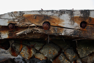 weathered wood and rusted bolts on coastal structure