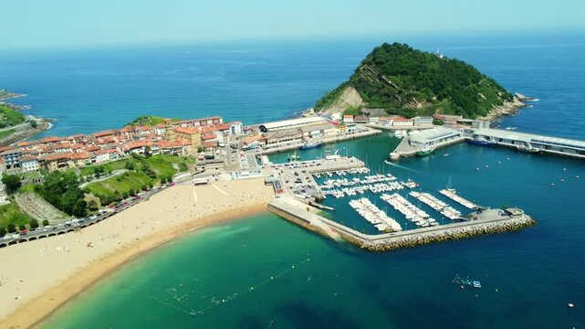 Aerial view of getaria town, port, beach, and san anton mountain in gipuzkoa, basque country, spain, during a sunny summer day