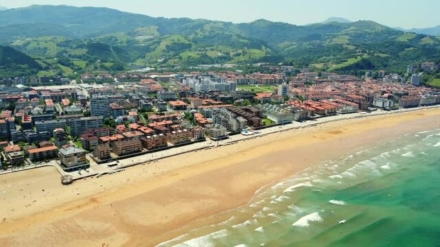 Aerial view of zarautz town, beach, and ocean waves in gipuzkoa, basque country, spain, during a sunny summer day