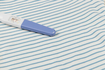 Pregnancy test on a striped fabric background