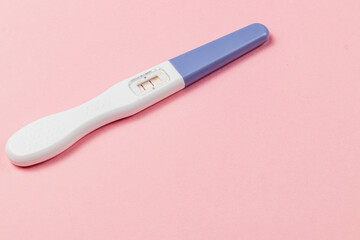 Pregnancy test showing two lines on a pink background