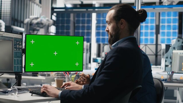 Solar panels inspection group review data on pc next to green screen, finding errors during a process audit and helping optimize renewable energy operations. Photovoltaics factory. Camera B.