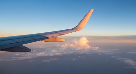 Obraz premium Airplane Wing Silhouetted Against Colorful Sky with Clouds