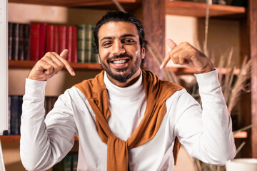 Choose online education. Indian teacher pointing at himself and laptop recommending virtual...