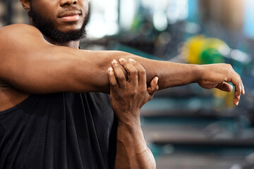 Warming up, stretching concept. Handsome african american bearded sportsman stretching his muscles...
