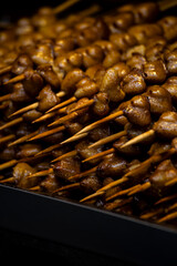 a large pile of grilled chicken butt skewers neatly arranged on a grill
