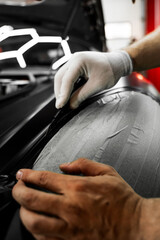 Vinyl film is carefully applied and trimmed with a blade for flawless vehicle wrapping results....