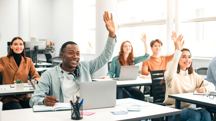 Presentation, Convention Concept. Portrait of smiling international people participating in seminar at modern office, raising hands up to ask question or to volunteer, diverse group sitting at tables