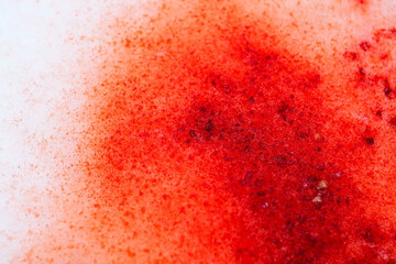 Red Stains on Snowy Surface. Close-Up of Textured Red Snow.Snow texture with blood drops.