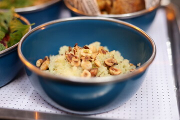 Sabores em tigelas azuis: uma composição de pratos variados, com saladas coloridas, arroz com amêndoas e batatas rústicas. A cena evoca uma experiência culinária diversificada e apetitosa.