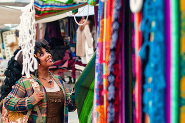 Obraz premium Tourist enjoying colorful handcrafted textiles at otavalo market
