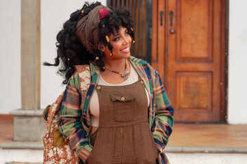 Smiling tourist exploring a colonial town with backpack and trendy clothes