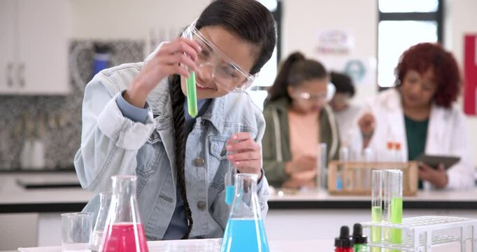 Girl conducting science experiment in school lab, focusing on test tubes