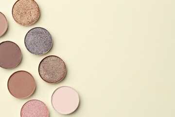 Beautiful eyeshadow refill pans on beige background, flat lay. Space for text