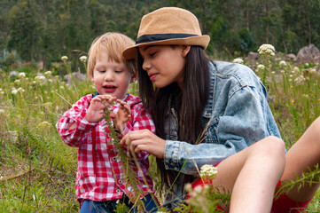Big sister showing little brother wildflowers growing in meadow