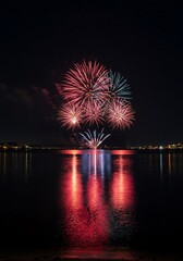 Fireworks over water at night celebration