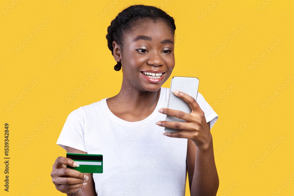 Aufkleber mobile shopping app. cheerful black female customer with smartphone using credit card paying online 