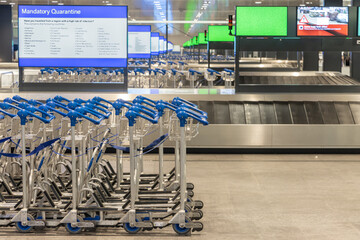 Empty airport hall with monitors warning of global quarantine