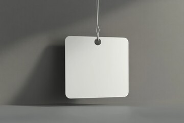 Square tag hangs against gray