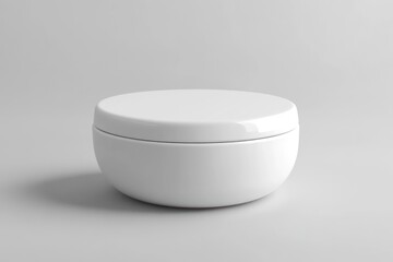 A plain, round, white container with a lid, set on a light surface