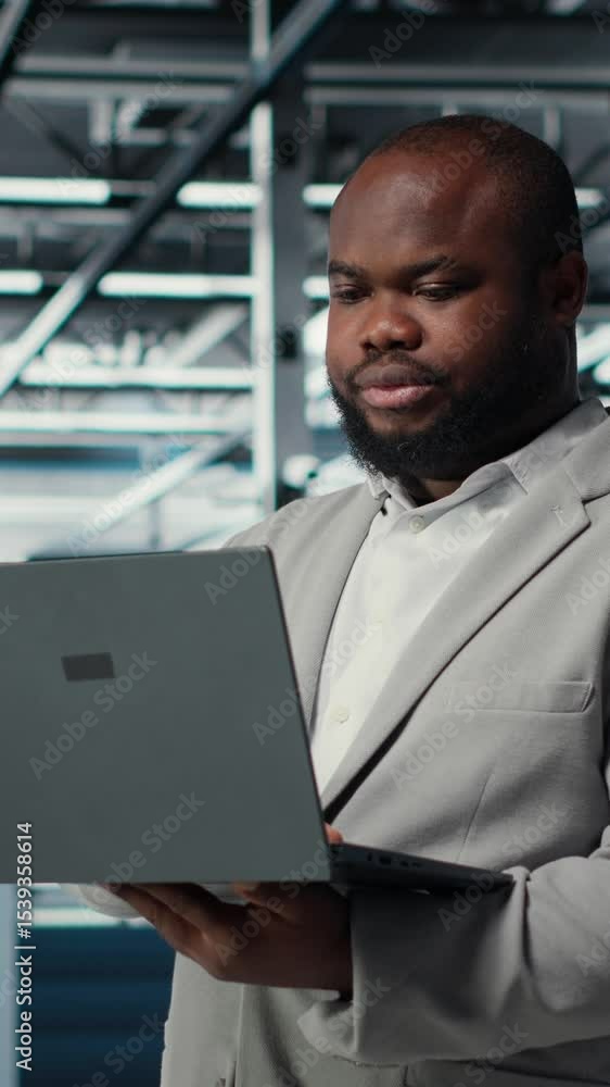 Poster vertical video engineer in data center using laptop to update storage arrays, configuring network vi