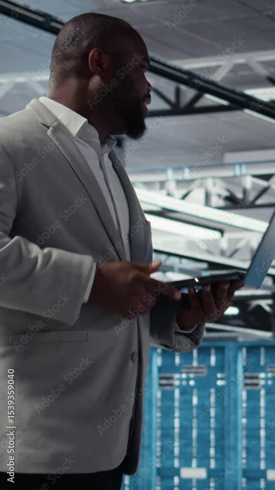 Poster vertical video admin walking in data center industrial platform analyzing infrastructure performance