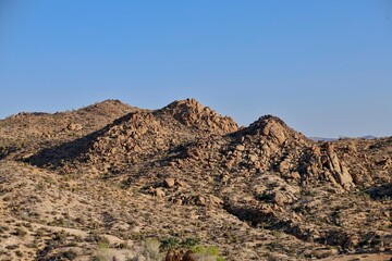 The late afternoon sun casts shadows on the rocky landscape of California's Joshua Tree National Park