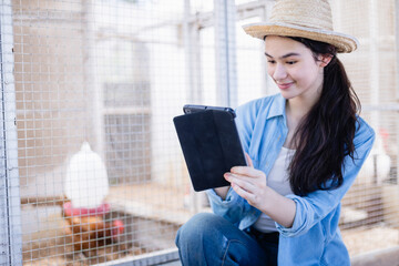Young scientist in farm setting uses tablet to assist with agricultural research as part of dedicated team, capturing data and observing animals with focused and happy expression