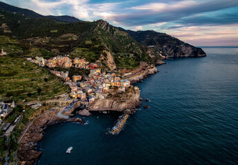 Aerial view of coastal village nestled between mountains and the sea under a cloudy sky in italy