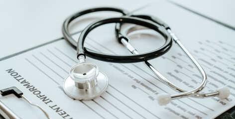 A stethoscope rests on a patient information form, symbolizing medical care, diagnosis, and...