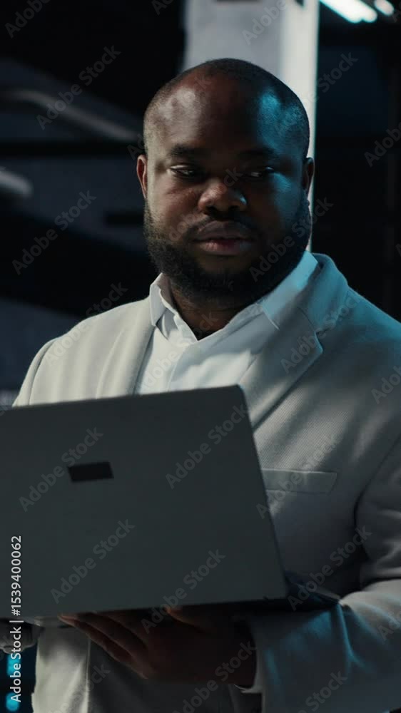 Poster vertical video data center it expert reviewing performance dashboards of equipment rigs. server room
