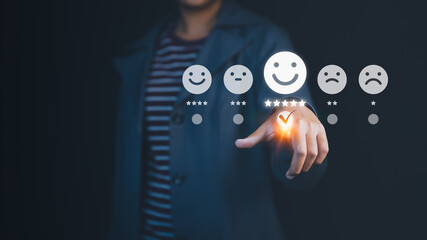Person touching the virtual screen on the happy smiley face icon to give satisfaction in service. Rating very impressed, customer service, online reviews, testimonial and customer satisfaction.