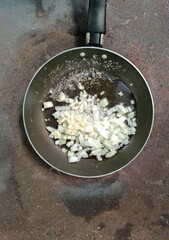 Traditional rural Guatemalan kitchen with chopped onions and garlic in a frying pan