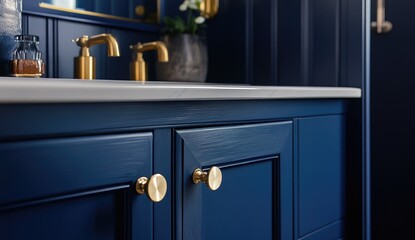 Close-up of a navy blue bathroom vanity with brass fixtures and knobs