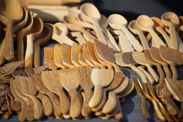 Beautiful display of artisanal wooden cooking spoons and spatulas shows natural wood grain texture.