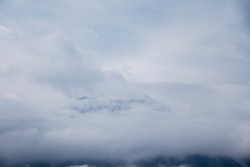 Snow-capped mountains in western China are barely visible after being obscured by clouds.