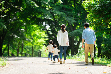 Obraz premium 新緑の公園を散歩する家族 