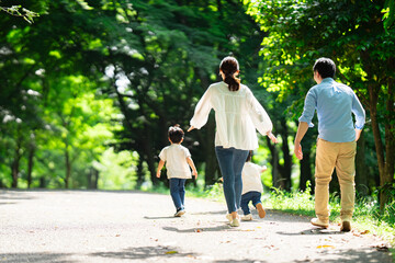 新緑の公園を散歩する家族	
